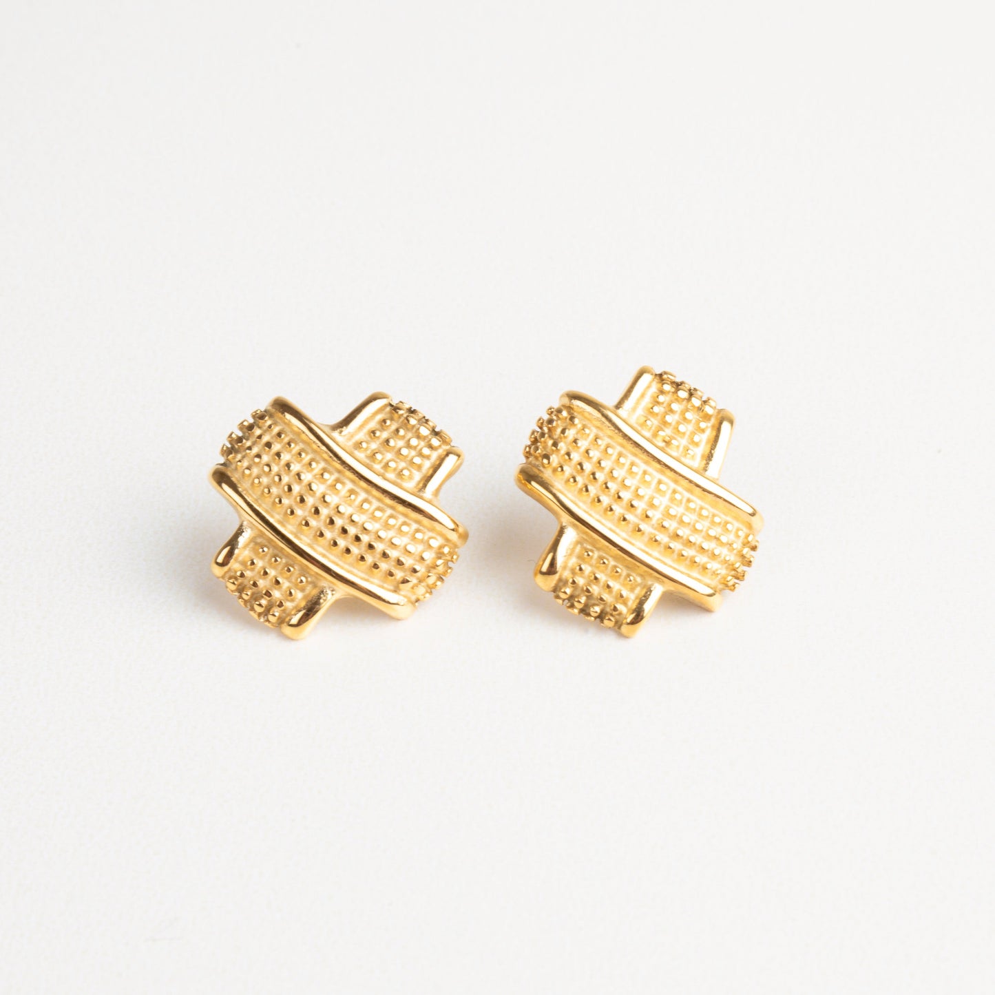 Aretes dorados tipo tacha con textura elegante, ideales para un look moderno y sofisticado