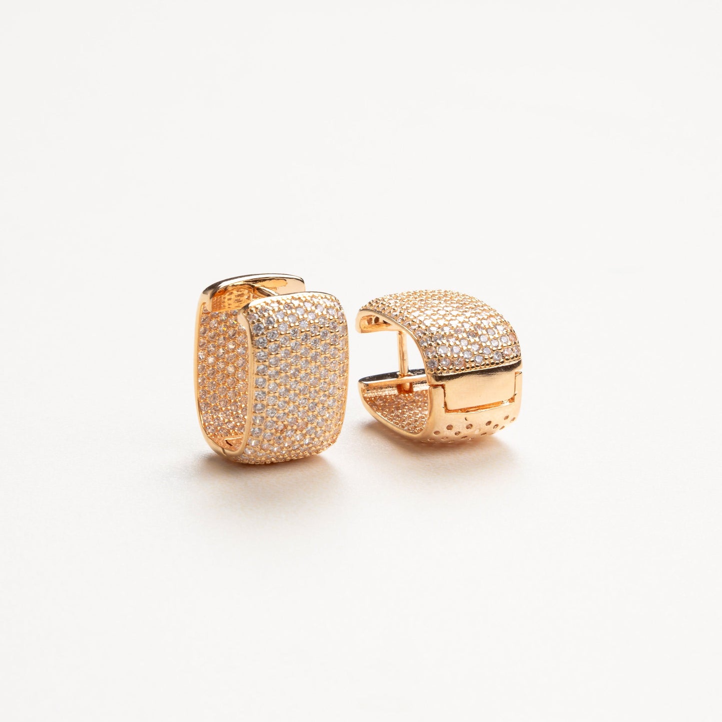 Detalle de los aretes con zirconias de tamaño mediano, mostrando el brillo y la claridad de las piedras, con una estructura delicada que aporta un toque moderno y refinado.