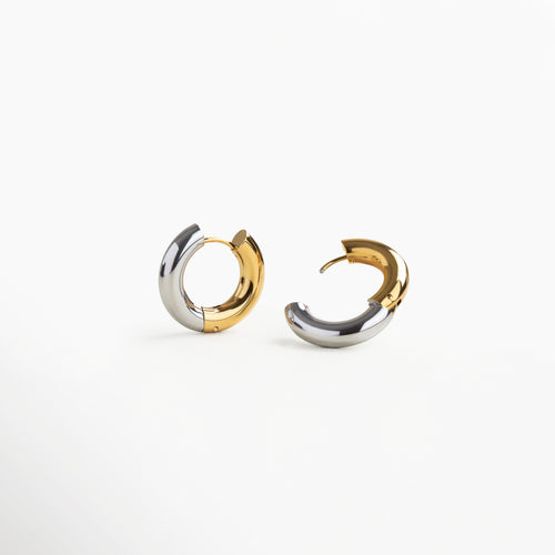 Detalle lateral de arracadas en dorado y plateado, Arracadas bicolor con acabado brillante de acero, Aretes chunky bitono vistos en ángulo, Pendientes bitono con acabado metálico dual, Vista en detalle de arracadas de acero inoxidable bitono