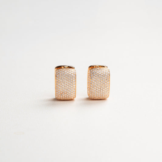 Elegantes aretes con zirconias medianamente grandes, brillando intensamente en un diseño sofisticado, ideal para ocasiones especiales y para dar un toque de lujo y estilo a cualquier look.